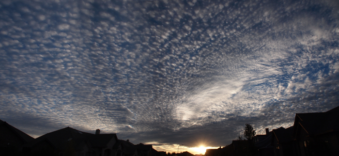 [Panoramic view with sunrise and rooftops just visible at the bottom of the image. The rest of the image is a cloud infested blue sky.]